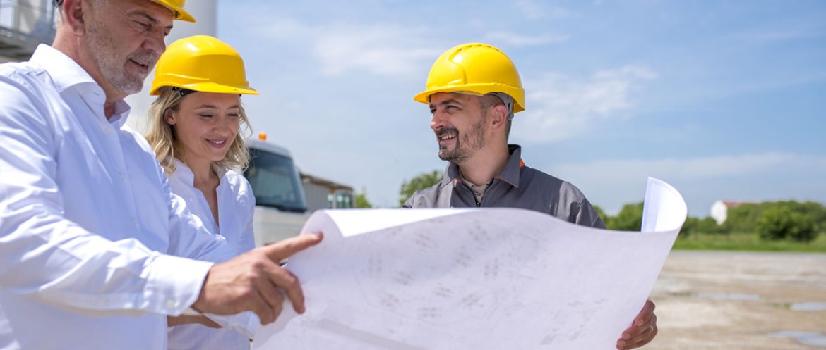 grupo-trabajadores-construccion-mirando-planos-documentos-luz-sol